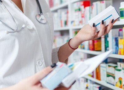 약사가 약국 선반 앞에서 약품 상자를 확인하는 장면은 어떤 뜻인가요? 관련 이미지 - 약사가 약국 선반 앞에서 약품 상자를 들고 내용을 확인하고 있습니다. 재고 관리 또는 처방전 조제 중인 것으로 보입니다.