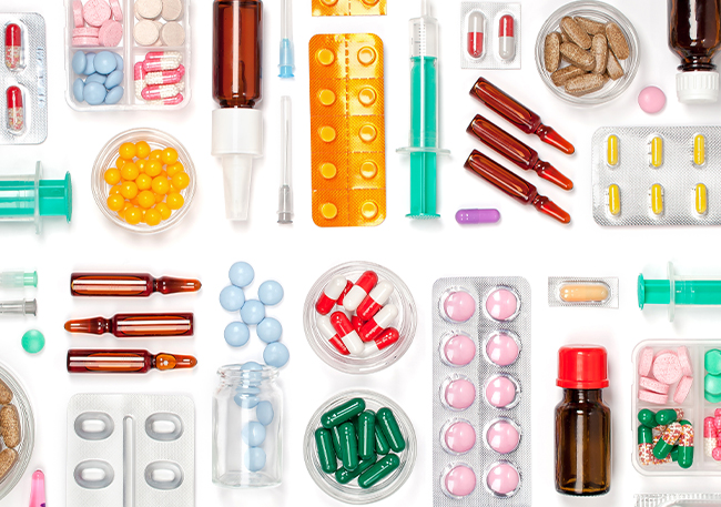확인 기준 관련 이미지 - 다채로운 알약, 캡슐, 주사기, 앰플 등 여러 종류의 의약품과 의료 도구들이 흰색 배경에 정돈되어 있습니다. 건강 관리 및 치료 관련 콘텐츠에 활용하기 좋습니다.