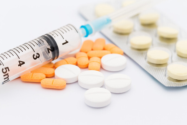 2. 상처 및 외상 관리 용품 관련 이미지 - 주사기, 다양한 색상의 알약, 블리스터 팩이 함께 놓여 있는 의료 용품 이미지입니다. 건강 관리 및 치료 관련 자료에 활용하기 적합합니다.